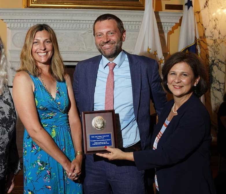 Erin Piorek Schofield '96 and Asher Schofield '96 receive the National Association of Secretaries of State Medal from Nellie Gorbea, Rhode Island secretary of state.