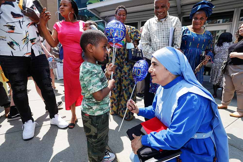 Mother Olga greets a child outside of the Dunkin Donuts Center