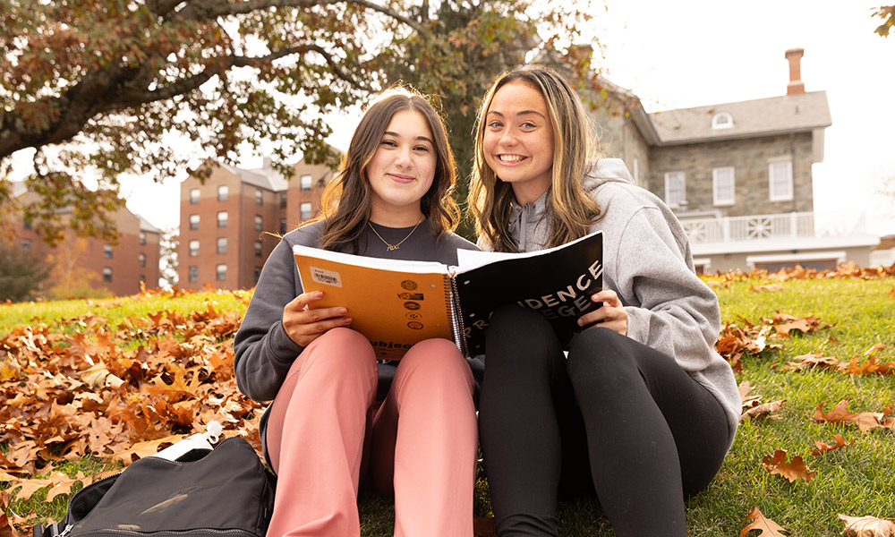 students with a book on campus