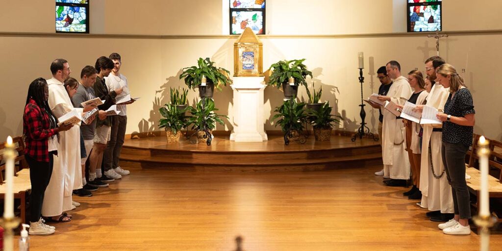 students and chaplains praying in St. Dominic Chapel