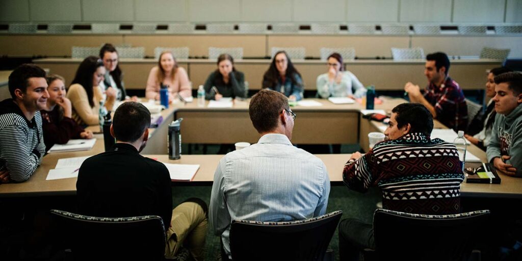 students and professor at seminar table