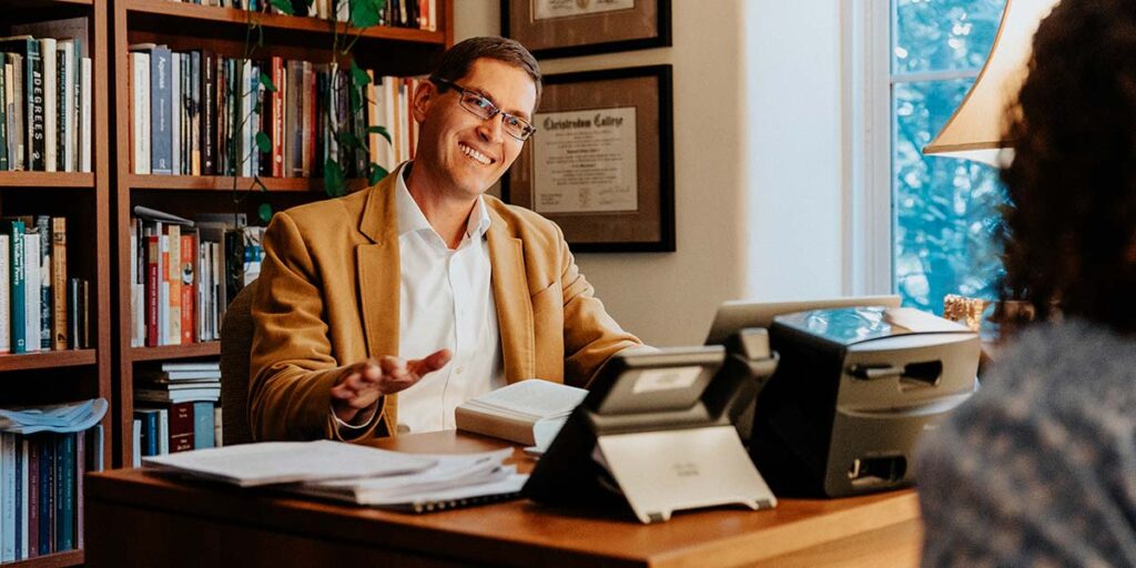 Raymond Hain, Ph.D, associate professor of philosophy and associate director of the humanities program, meets with a student in his office in Siena Hall.