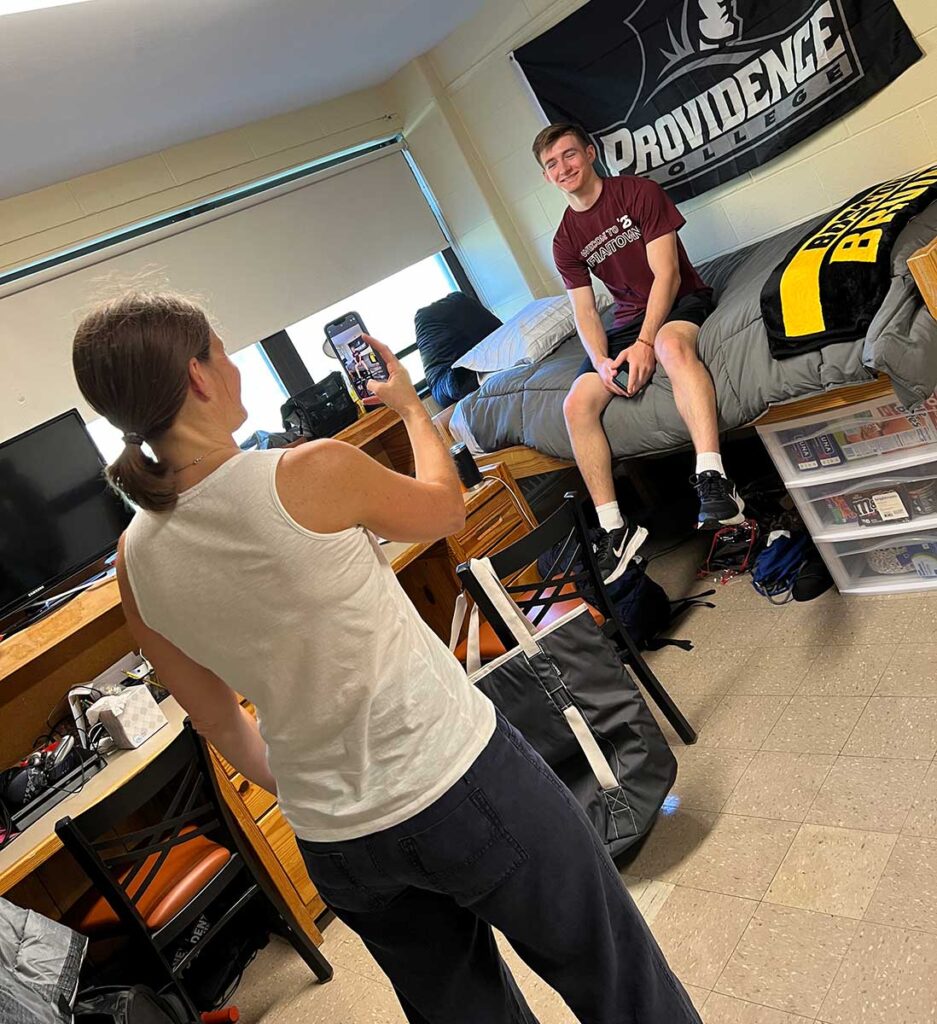 A young man from the Class of 2026 poses for a photo in his new residence hall room.