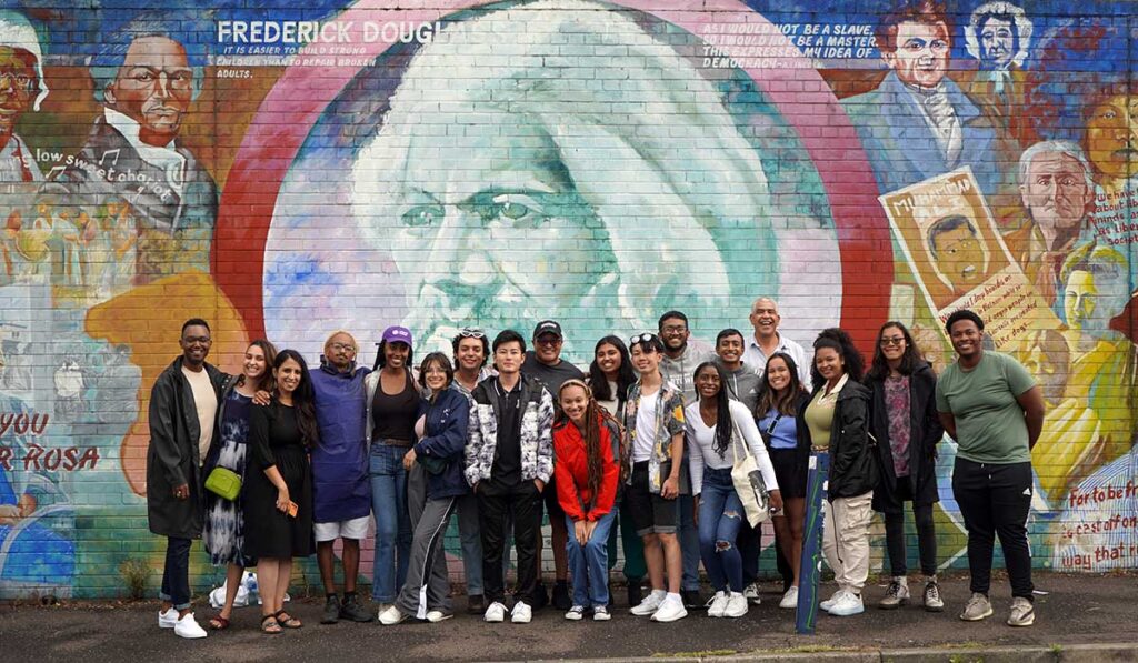 The 2022 Frederick Douglass International Fellows pose at a mural of Douglass in Belfast, Northern Ireland
