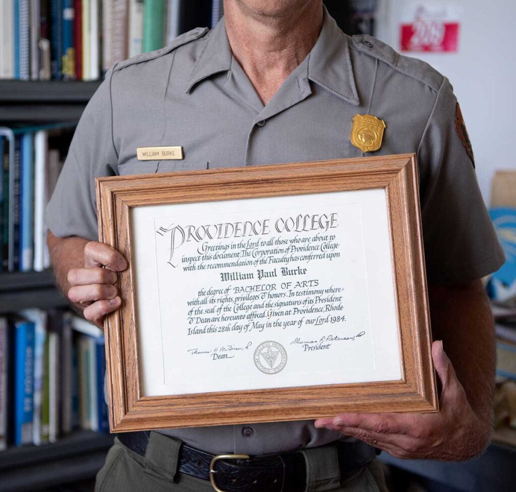 Bill Burke '84 keeps his Providence College diploma, and the history award he received at graduation, on display in his office in the Salt Pond Visitor Center in Eastham.