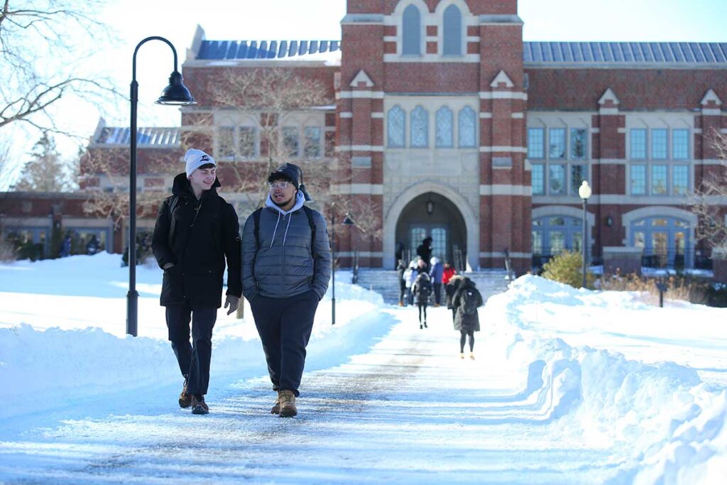 Myles Forgue '24 talks with Santiago Najarro Cano '24 on a winter day outside the Ruane Center for the Humanities.