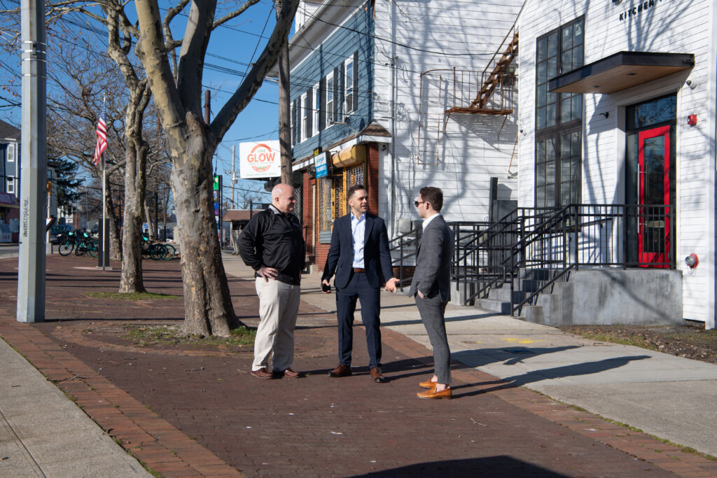 Joseph Colaluca '09, '15G, center, on Admiral Street with general counsel John Longo, left, and brand manager Kenneth McCarthy '23.