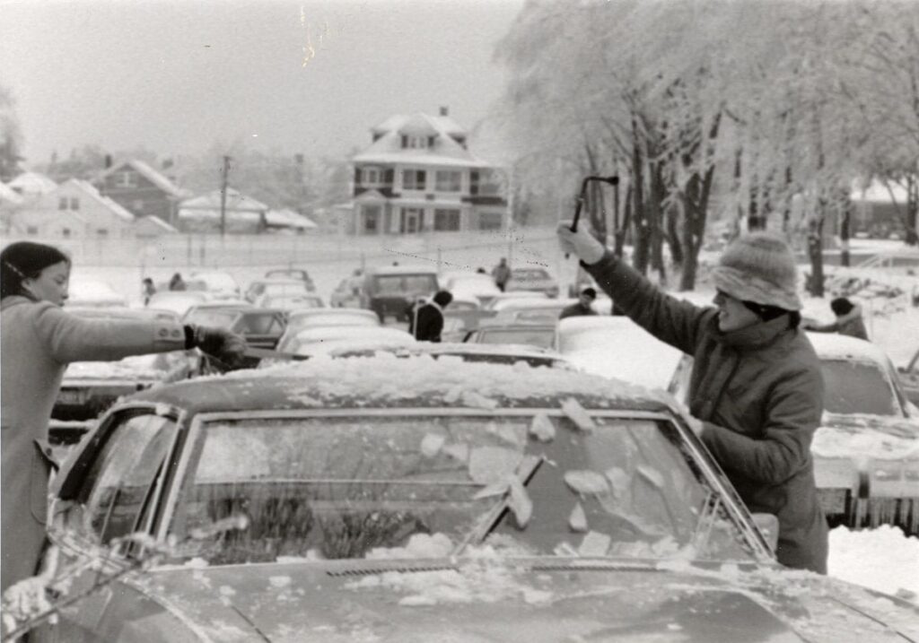 Students cleaning snow off their car