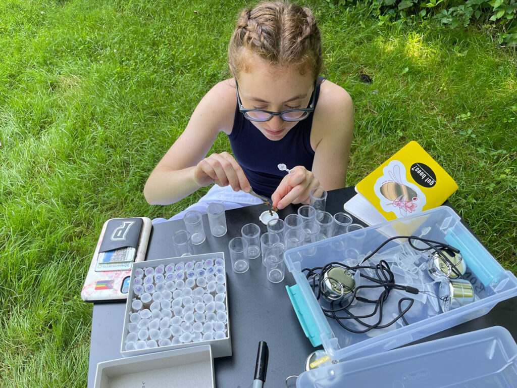 On PC's campus, Kaitlyn Bresnahan '25 gently squeezes bees to cause them to “spit up” the nectar they were carrying back to the hive. The nectar is then analyzed for nutritional content in the lab. The bees return to their hives unharmed.