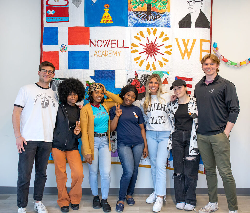 Colby Brown '24, far left, with Nowell Academy students and PC financial tutors Linsey Conca '25, third from right, and Timothy Gagliano '25, far right.