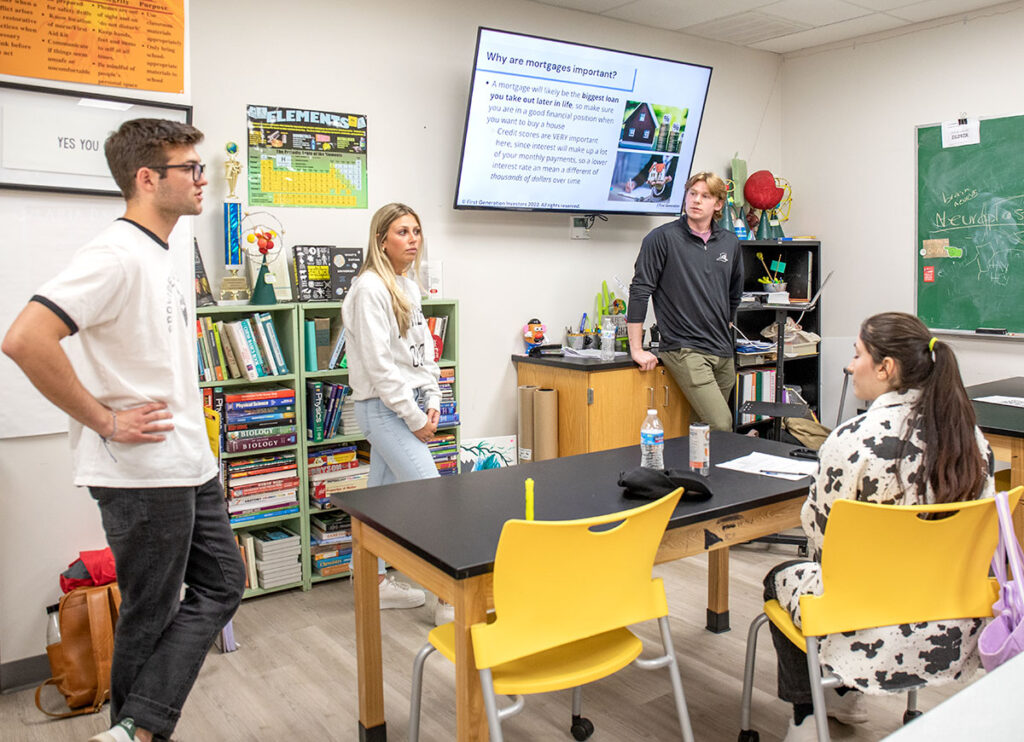 Colby Brown '24, far left, leads a financial lesson with other tutors at Norwell Academy, a Providence-based high school for underserved students.