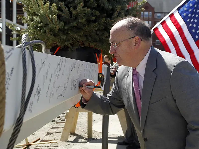 Dr. Lena signs a beam during construction of the Arthur F. and Patricia Ryan Center for Business Studies in April 2016.