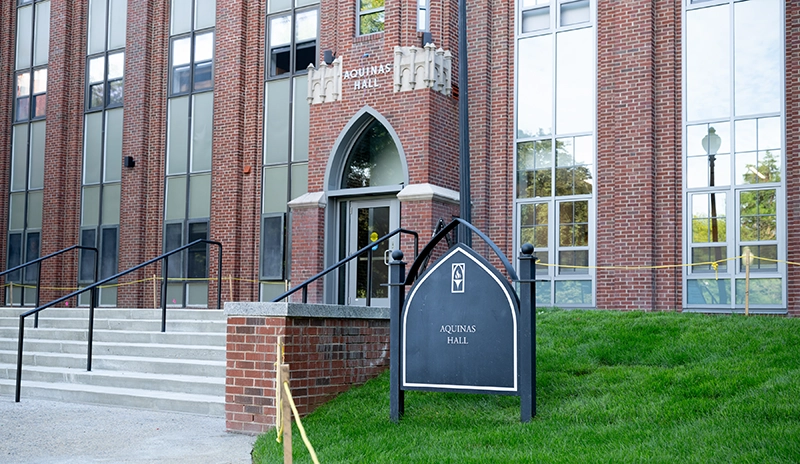 Brick building with cement stairs and tall windows, some new, some old
