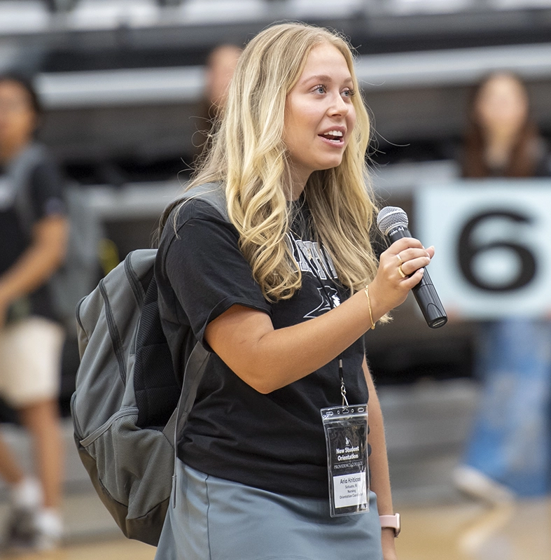 Aria Kriticos '27 holds a microphone