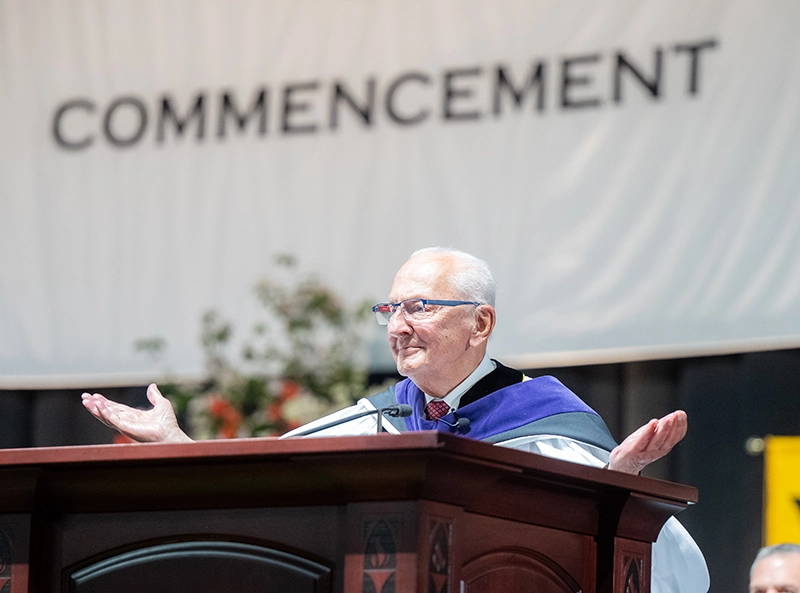 Retired Providence Municipal Court Judge Frank Caprio, J.D. '58, '08Hon., gestures to graduates during his commencement address.