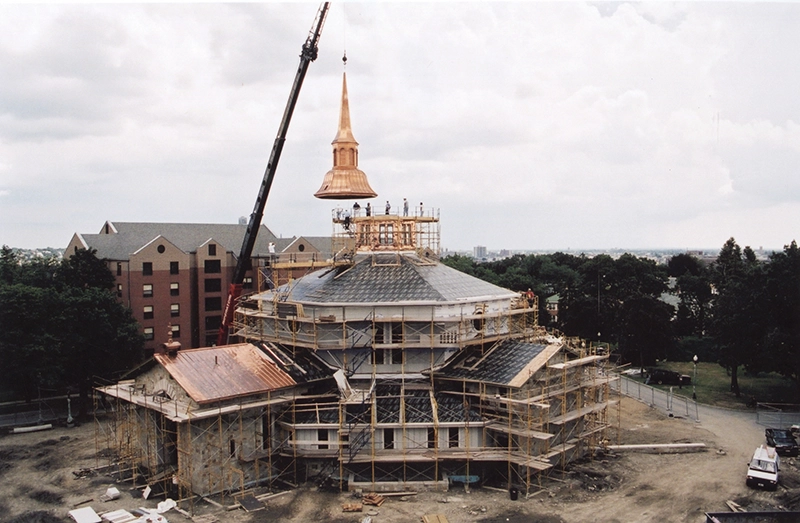 The steeple is raised on St. Dominic Chapel by a giant crane in this photo taken in 2000.