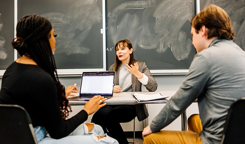 Andrea McDonnell, Ph.D., director of the Communication Program, meets with students.