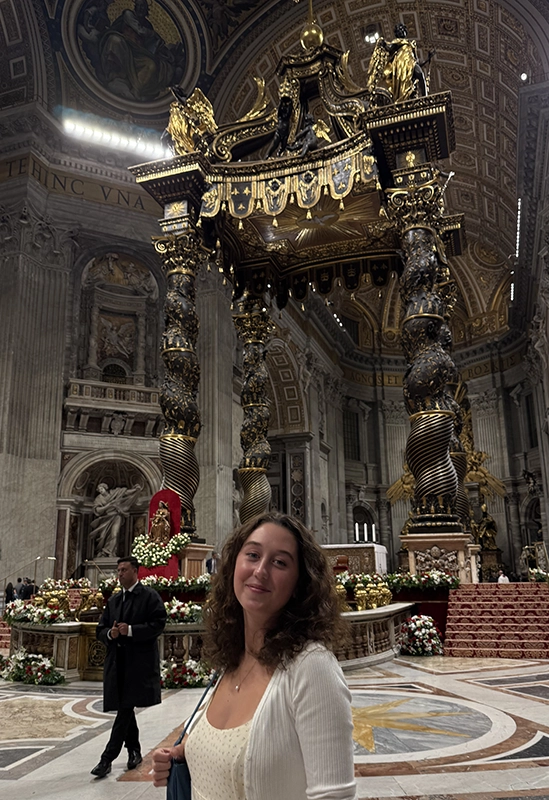Ella Bloom '27 stands before the ornate seat of St. Peter in the basilica in Rome.