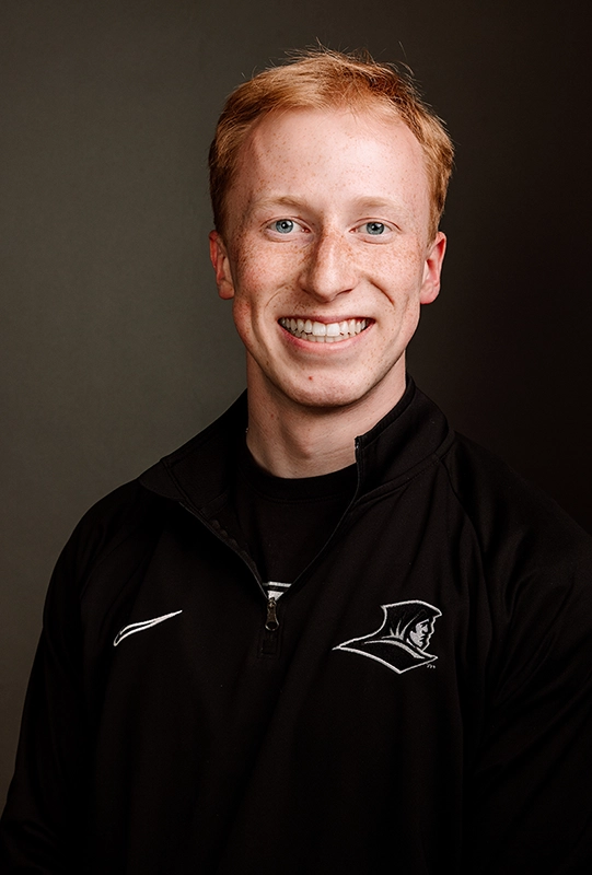 Connor Enestvedt '26 wearing a black quarterzip with the Friar head logo.