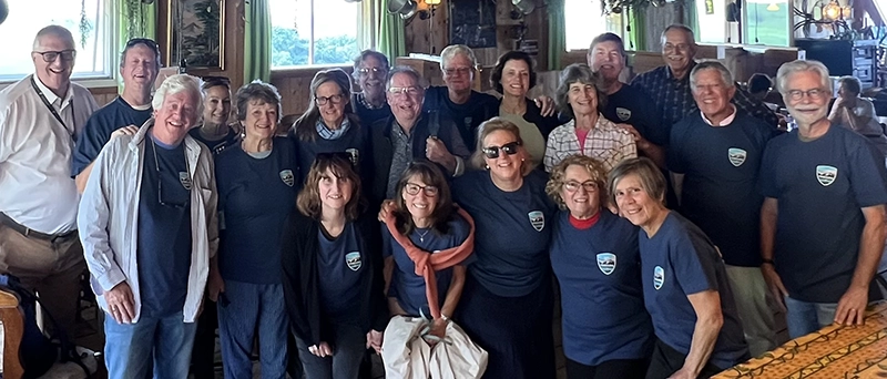 A group of people gather around a table in Fribourg, Switzerland, reuniting after 50 years.