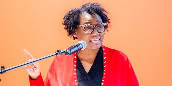 Gloria Purvis speaking before a microphone at an event at Providence College.