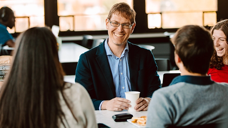 Raymond Hain, Ph.D., humanities professor, meets with students in Raymond Dining Hall.