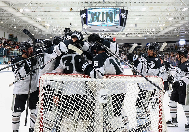 Sticks are raised near the net in celebration of a win over Boston College. 