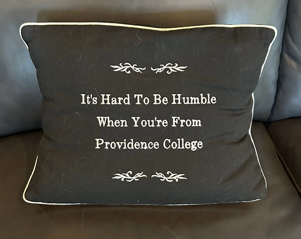 Black and white pillow with stitching that reads, "It's hard to be humble when you're from Providence College."