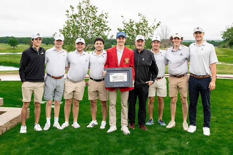 Logan Jaeger '25, in red jacket at center of photo, with the plaque he was awarded after winning the national club golf competition in Oklahoma.