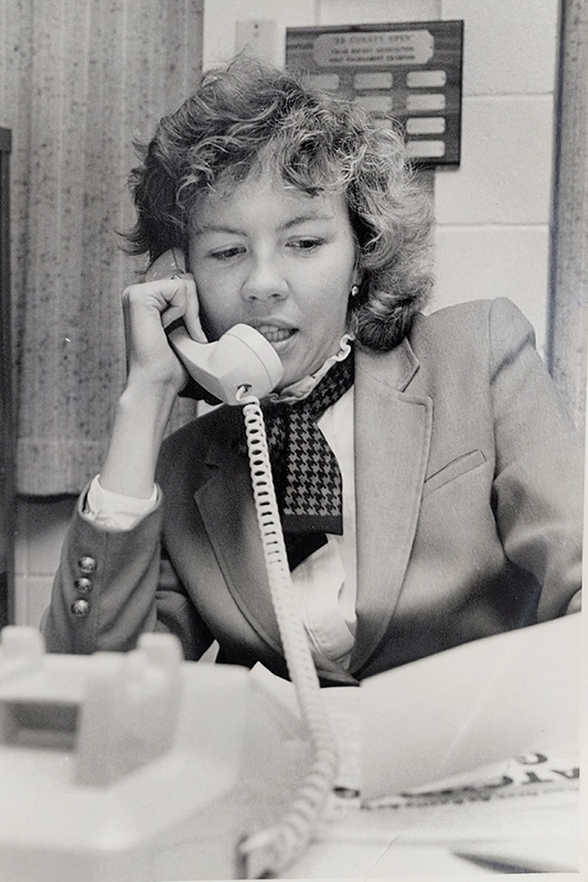 Kathleen McGinley '82 on the telephone in the 1980s, making calls for donations to the college.
