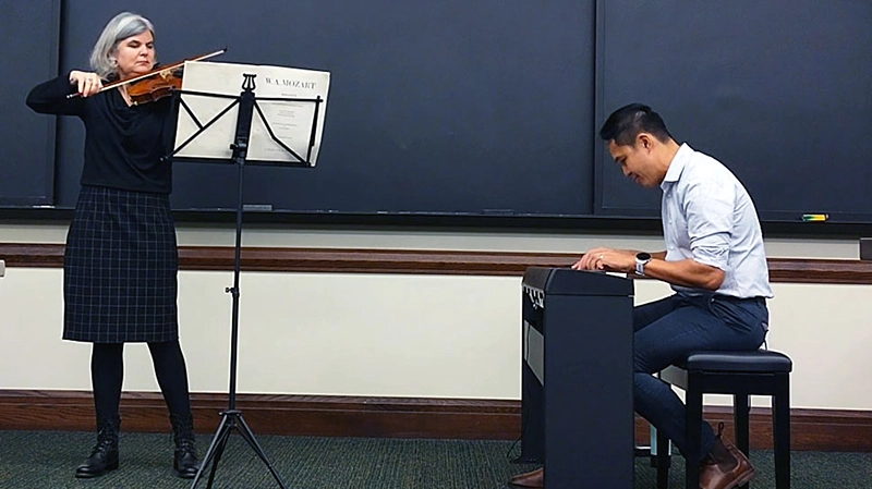 Licia Carlson, Ph.D., and Alex Orquiza, Ph.D., professors at Providence College, perform Mozart in the classroom.