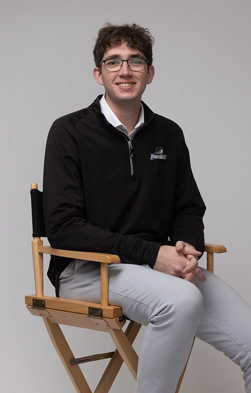 Nathan Cross '26 seated in a director's chair.