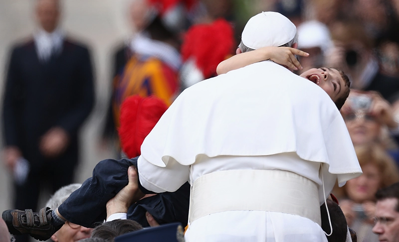 Pope Francis cradles Dominic Gondreau, son of Providence College theology professor Paul Gondreau, during Easter Mass in St. Peter's Square in 2013.