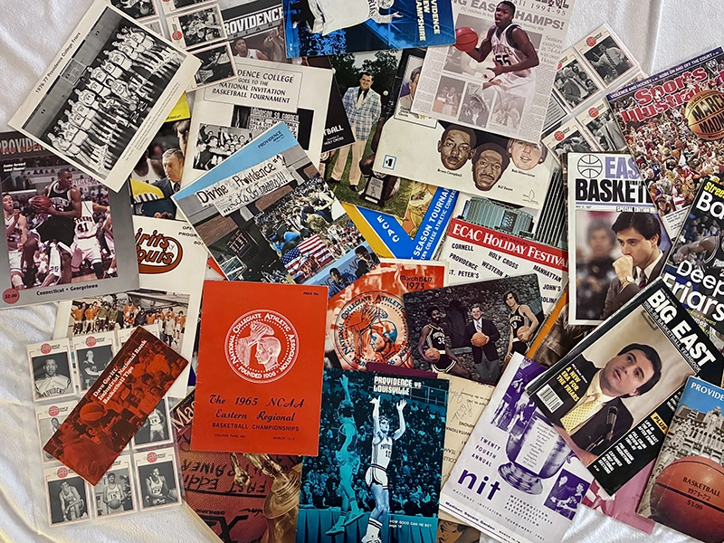 Basketball game programs with illustrations and photos of players on the covers.