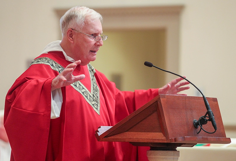 Rev. James Quigley, O.P. '60, associate alumni chaplain, proclaims the Gospel at Mass.