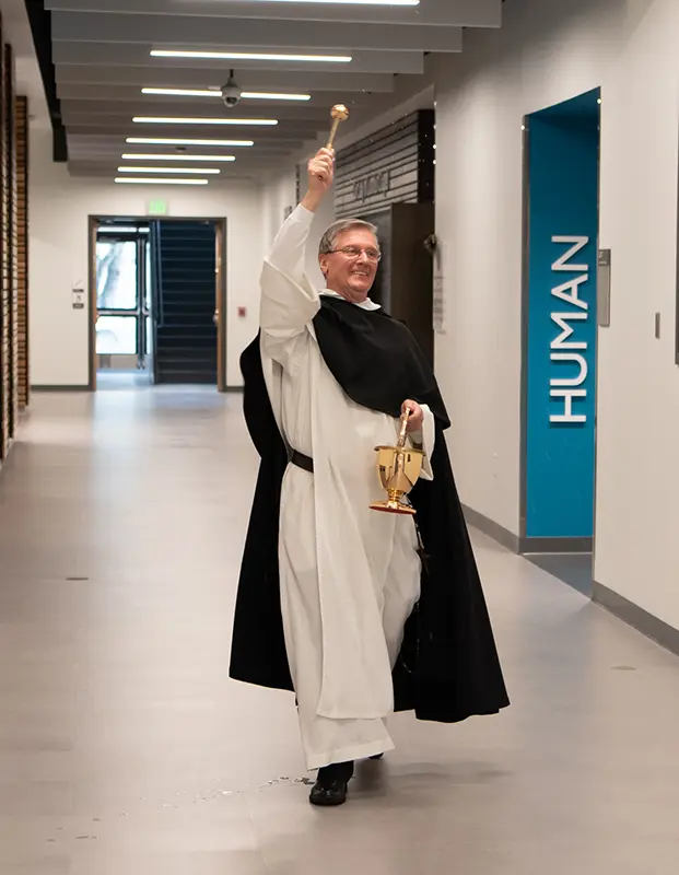 College President Rev. Kenneth R. Sicard, O.P. '78, '82G blesses the Mondor Center with holy water during the dedication.