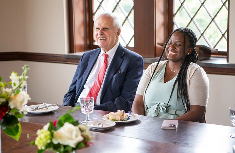 Ron Stride '62, '25Hon. shares a laugh with students at a lunch preceeding commencement. With him is Linda Ineus '22.