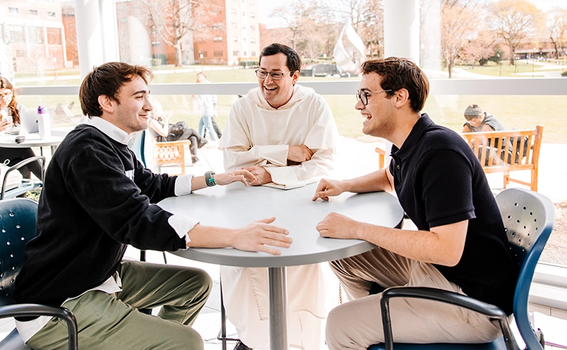 Francis Brissette '26, left, and his brother, John Paul Brissette, with chaplain Rev. Simon Teller, O.P., in Slavin Center.