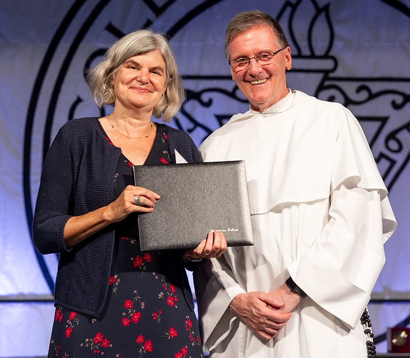 Licia Carlson, Ph.D., received the Outstanding Faculty Scholar Award from College President Rev. Kenneth R. Sicard, O.P. '78, '82G.