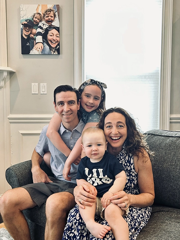 Brendan and Kerri Palamara McGrath, M.D. '02 with daughter, Sloane, and son, Miles (born May 2023), in front of their favorite family photo with Colin.
