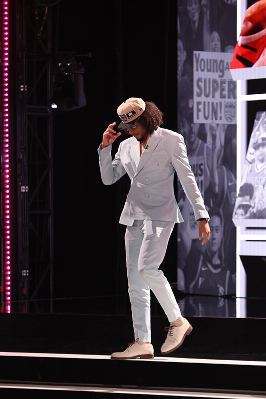 Devin Carter leaves the stage following the NBA Draft wearing a Sacramento Kings cap.