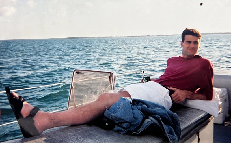Marty Graham '92 reclines on a boat. He died of cancer during his time at PC and his fellow students created a scholarship in his memory.