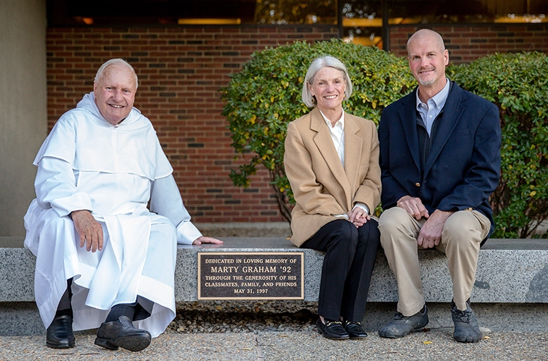 Rev. James Quigley, O.P. '60, associate alumni chaplain, with Charlene Graham, mother of the late Marty Graham '92, and Marty's brother, Mel Graham.