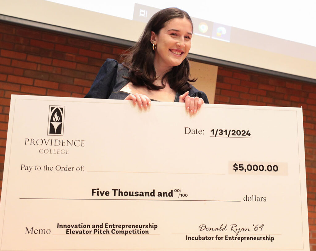 Mary Gifford '26 with the $5,000 check was awarded after winning the college's first Innovation and Entrepreneurship Competition. She will represent PC at the BIG EAST Startup Competition.