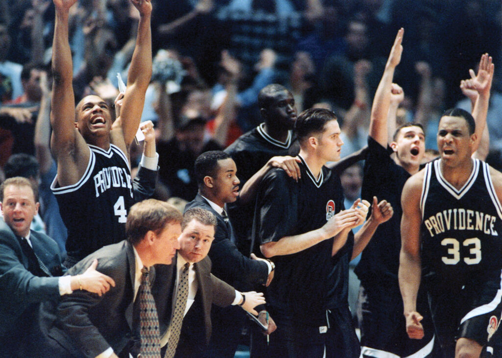 Rick Cordella ’99 celebrates behind #33 Jamel Thomas after Thomas’ game-tying three-point shot against Arizona with 30 seconds left in the Elite Eight of the 1997 NCAA Tournament. From left: Bobby Gonzalez, Kofi Pointer, head coach Pete Gillen, Tom Herrion, Alexis Sherard, Ndongo Ndiaye, and Austin Croshere. The Friars lost in overtime to Arizona, the eventual national champions.
