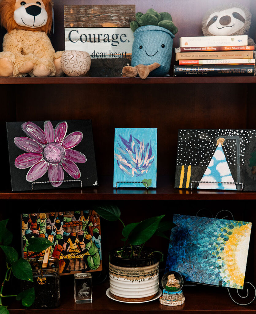 Items on display inside the Personal Counseling Center, including stuffed animals, paintings, books, and a plant.