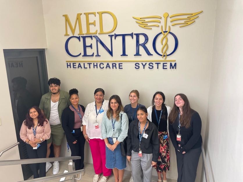 group of students standing in front of MedCentro sign