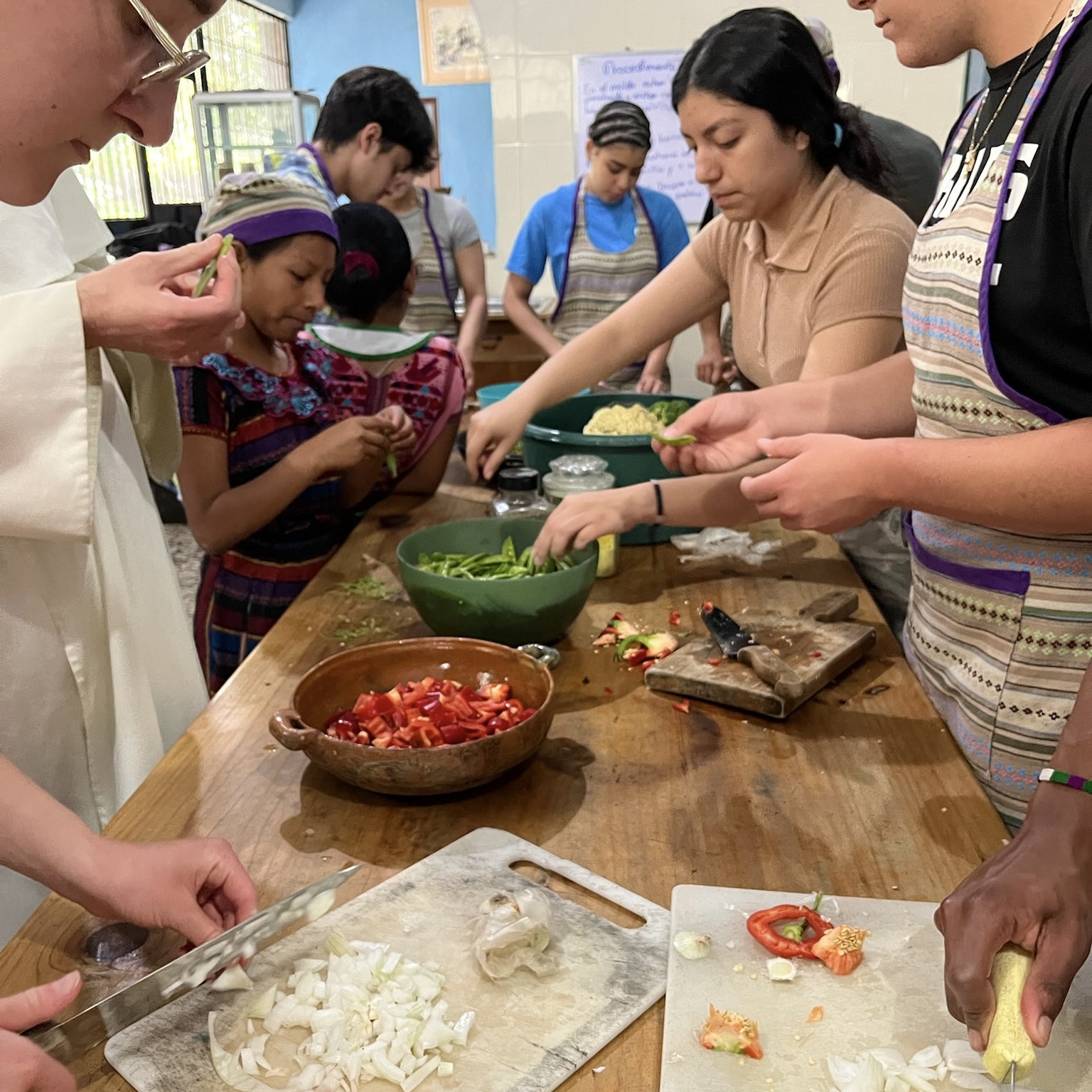Students and locals chopping vegetables in the kitchen