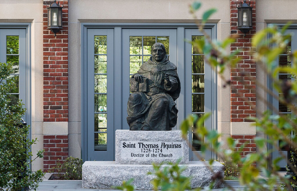 The St. Thomas Aquinas statue between Phillips Memorial Library and the Ruane Center for the Humanities. 