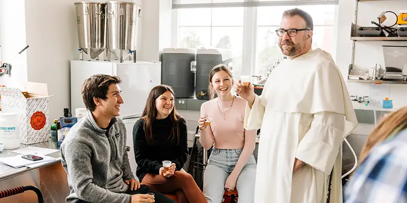 Father Jordan Zajac samples 1.5-ounce servings with students in the Beer class